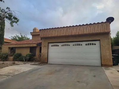 a house with a garage door in a driveway at 3BR & Loft near Palmdale Hospital in Palmdale
