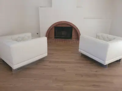 two white couches in a room with a fireplace at 3BR & Loft near Palmdale Hospital in Palmdale