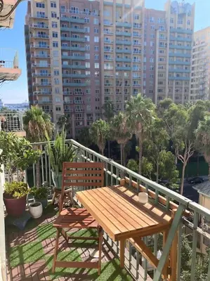 a wooden table and chairs on a balcony with buildings at Luxe Suite Convention Center Partial Ocean View with Free Parking in Long Beach