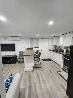a kitchen with white cabinets and a table and chairs at RGS cottage in Los Angeles in Los Angeles