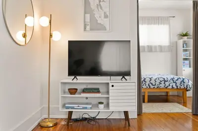 a living room with a television on a white dresser at Walk to Beach and Restaurants - Easy Parking in Long Beach
