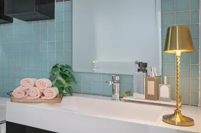 a bathroom counter with a sink with a lamp and towels at Gorgeous Apartment 2-bedroom 2-bathroom in Los Angeles