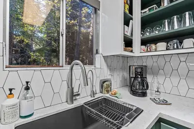 a kitchen counter with a sink and a window at Fleming Creek Hideaway, Next to Creek, Fire-Pit! in Lake Arrowhead