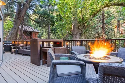 a deck with a table and chairs and a fire pit at Fleming Creek Hideaway, Next to Creek, Fire-Pit! in Lake Arrowhead