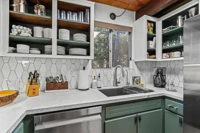 a kitchen with green cabinets and a sink at Fleming Creek Hideaway, Next to Creek, Fire-Pit! in Lake Arrowhead