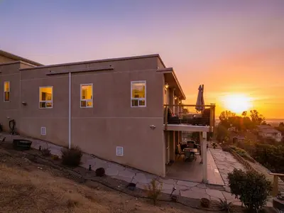 a house with the sunset in the background at 3BR Mountain Retreat with 2 Executive Suites & Scenic Views Sleeps 6 in Newbury Park
