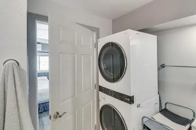 a white laundry room with a washer and dryer at The Surf Retreat in Newbury Park