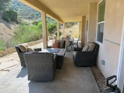 a patio with wicker chairs and a table on a porch at The Surf Retreat in Newbury Park