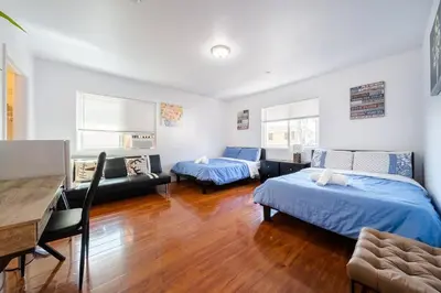 a bedroom with two beds and a table and a desk at 22ppl Garage Parking Btw Disney Hollywood Monterey Park Chinatown in Monterey Park