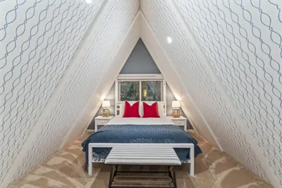 a bedroom with a bed with red pillows at Rocky Point Paradise Bay Lake Front Hot TUB 10 out of 10 in Lake Arrowhead