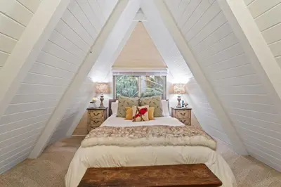 a bedroom with a large bed in a attic at Rocky Point Paradise Bay Lake Front Hot TUB 10 out of 10 in Lake Arrowhead