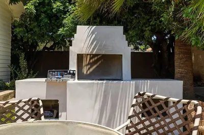 two chairs sitting at a table with a grill at 1970s Style Cozy Home with Fireplace Yard and Hot Tub in Inglewood