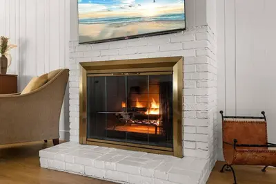 a white brick fireplace with a television above it at 1970s Style Cozy Home with Fireplace Yard and Hot Tub in Inglewood