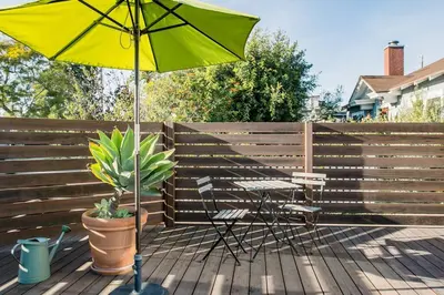 a yellow umbrella and chairs on a wooden deck at Perfect Venice Beach Vacation Home for Couples and Families in Los Angeles