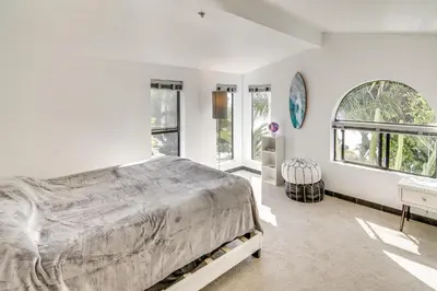 a white bedroom with a large bed and windows at 3 Mi to Beach Home with Pool and Spa in Malibu! in Malibu