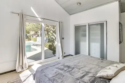 a bedroom with a bed and a large window at 3 Mi to Beach Home with Pool and Spa in Malibu! in Malibu