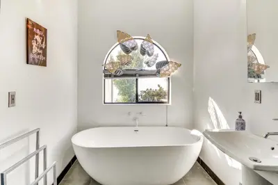 a white bathroom with a tub and a sink at 3 Mi to Beach Home with Pool and Spa in Malibu! in Malibu