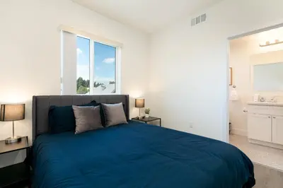 a bedroom with a blue bed and a large window at La Veranda View Hideaway in Los Angeles