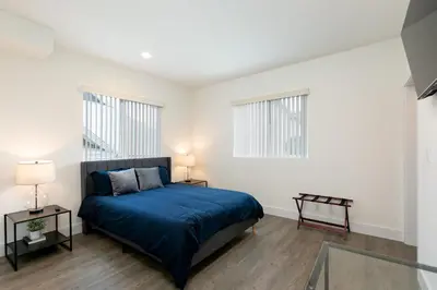 a bedroom with a bed and two windows at La Veranda View Hideaway in Los Angeles