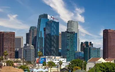 a city skyline with tall buildings and a plane in the sky at La Veranda View Hideaway in Los Angeles
