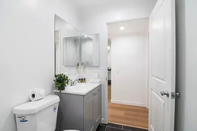 a white bathroom with a toilet and a sink at 2BR Plus Bonus Room and Pool Access Near Universal Studios in Los Angeles