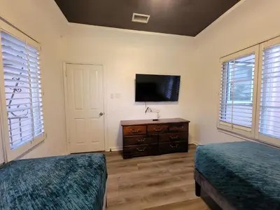 a bedroom with two beds and a flat screen tv at 3 bedroom top story apartment near Pico blvd in Los Angeles