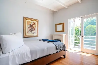 a white bedroom with a bed and a window at Sunset Hilltop Flat in Los Angeles