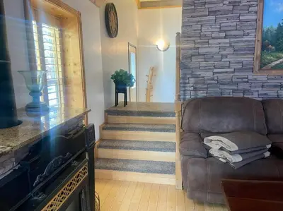 a living room with a couch and a staircase at Cabin 7 sleeps 8 BEAUTIFUL BOULDER BAY, BIG BEAR in Big Bear Lake