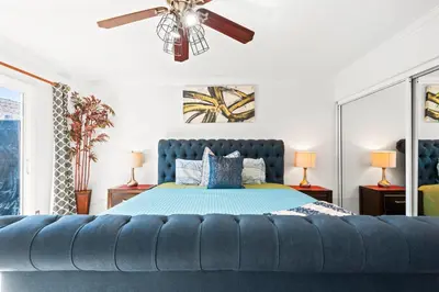a bedroom with a blue bed and a ceiling fan at Gated 6beds 2garage home near Disney other LA attraction in Chino