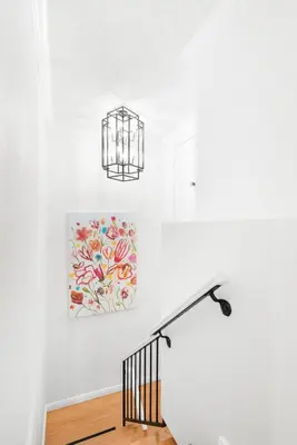 a staircase with a chandelier and a painting on the wall at 5bed 3bath Private gated community home 7miles to Downtown La close to Disney in Commerce