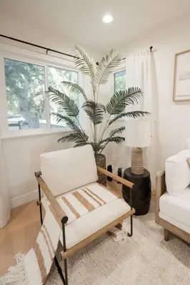 a living room with a chair and a palm tree at Jies choice- Modern Luxe in Altadena in Altadena