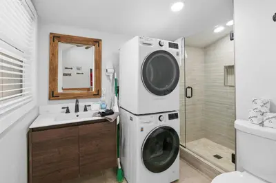 a washer and dryer in a bathroom with a sink at Little Lux - Hot Tub, Walk to Village & Lake in Big Bear Lake