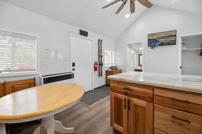 a kitchen with a wooden table and a counter top at Little Lux - Hot Tub, Walk to Village & Lake in Big Bear Lake
