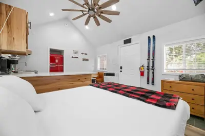 a white bedroom with a bed and a refrigerator at Little Lux - Hot Tub, Walk to Village & Lake in Big Bear Lake