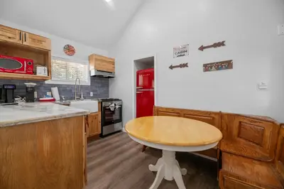 a kitchen with a wooden table and a red refrigerator at Little Lux - Hot Tub, Walk to Village & Lake in Big Bear Lake