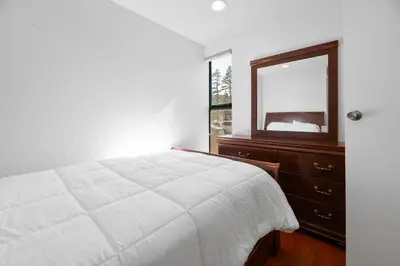 a bedroom with a bed and a dresser and a mirror at Lakeview Condo - Lakefront Complex, Lake Views, Heated Pool in Big Bear Lake