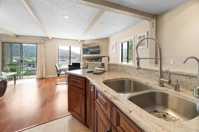 a kitchen with a large sink and a living room at Lakeview Condo - Lakefront Complex, Lake Views, Heated Pool in Big Bear Lake