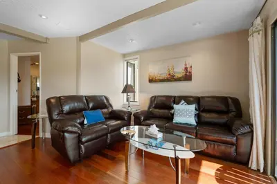 a living room with two leather couches and a table at Lakeview Condo - Lakefront Complex, Lake Views, Heated Pool in Big Bear Lake