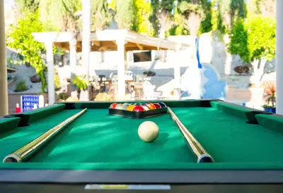 a green pool table with a cue ball on it at Resort Home with Games, Slide, Oasis in Los Angeles