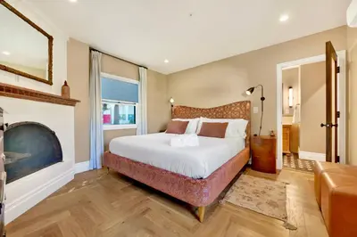 a bedroom with a large bed and a fireplace at Villa Encanto- LUXE Spanish Villa with 6 KING Bedrooms, Courtyard and New Game Room in Long Beach
