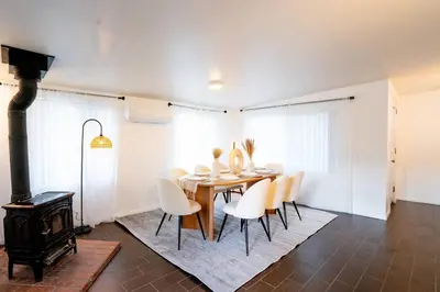 a dining room with a table and chairs and a stove at Stylish Cozy, Aesthetic, Stocked Kitchen, and Pet Friendly in Palmdale