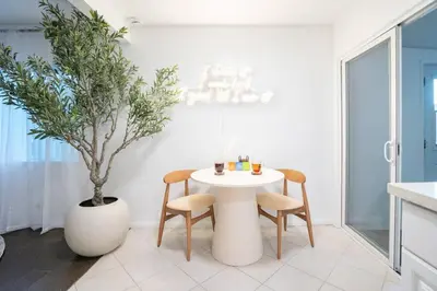 a kitchen with a table and chairs and a potted plant at Stylish Cozy, Aesthetic, Stocked Kitchen, and Pet Friendly in Palmdale