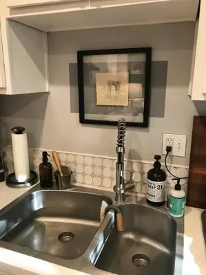 a kitchen sink in a kitchen with a picture on the wall at Beautifully Restored Pasadena English Cottage in Pasadena