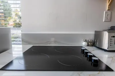 a black stove top in a kitchen with a microwave at Walking distance to Caltech convention Center Pasadena Landmark room in Pasadena
