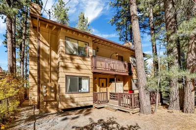 a log home with a balcony and a tree at Buttercup #2508 in Big Bear Lake