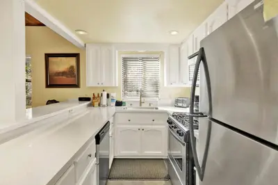 a kitchen with white cabinets and a stainless steel refrigerator at Buttercup #2508 in Big Bear Lake