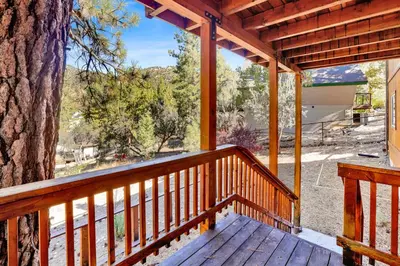 a wooden porch with a large tree on it at Lookout Lodge #2128 in Big Bear City