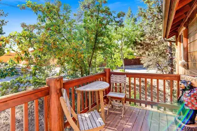 a wooden deck with chairs and a table on it at Lookout Lodge #2128 in Big Bear City