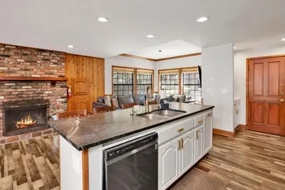 a kitchen with a sink and a fireplace at Serenity Cove Lake House #2472 by Big Bear Vacations in Big Bear Lake