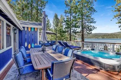 a deck with a table and chairs and a hot tub at Serenity Cove Lake House #2472 by Big Bear Vacations in Big Bear Lake